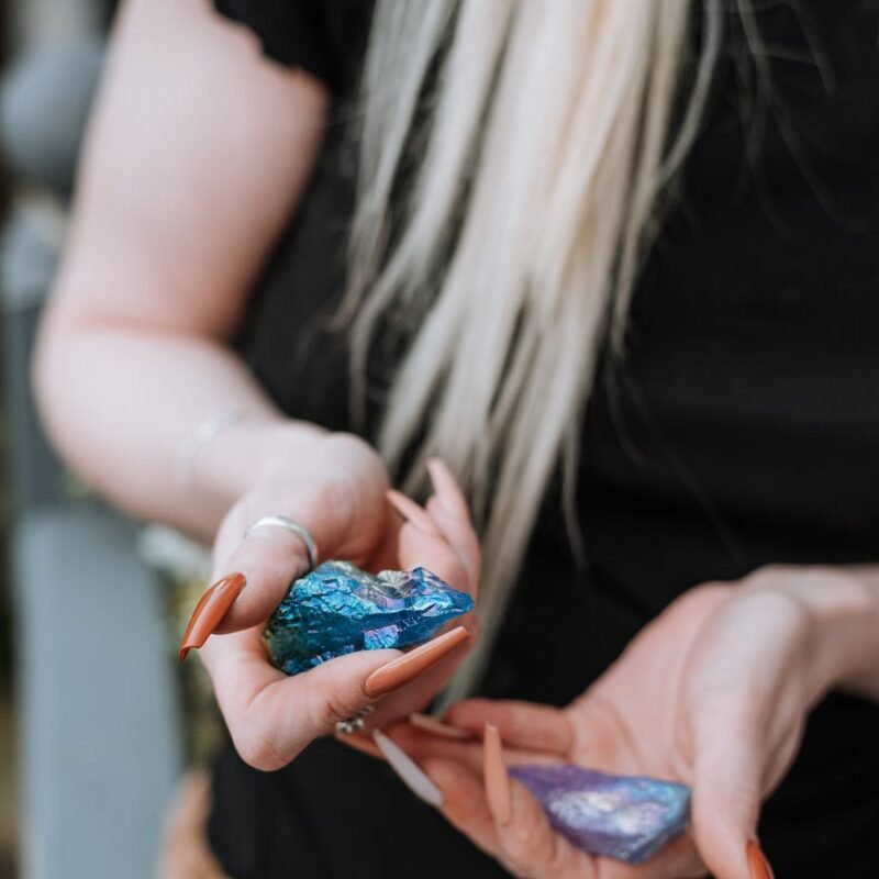 crop woman with colorful minerals in hands